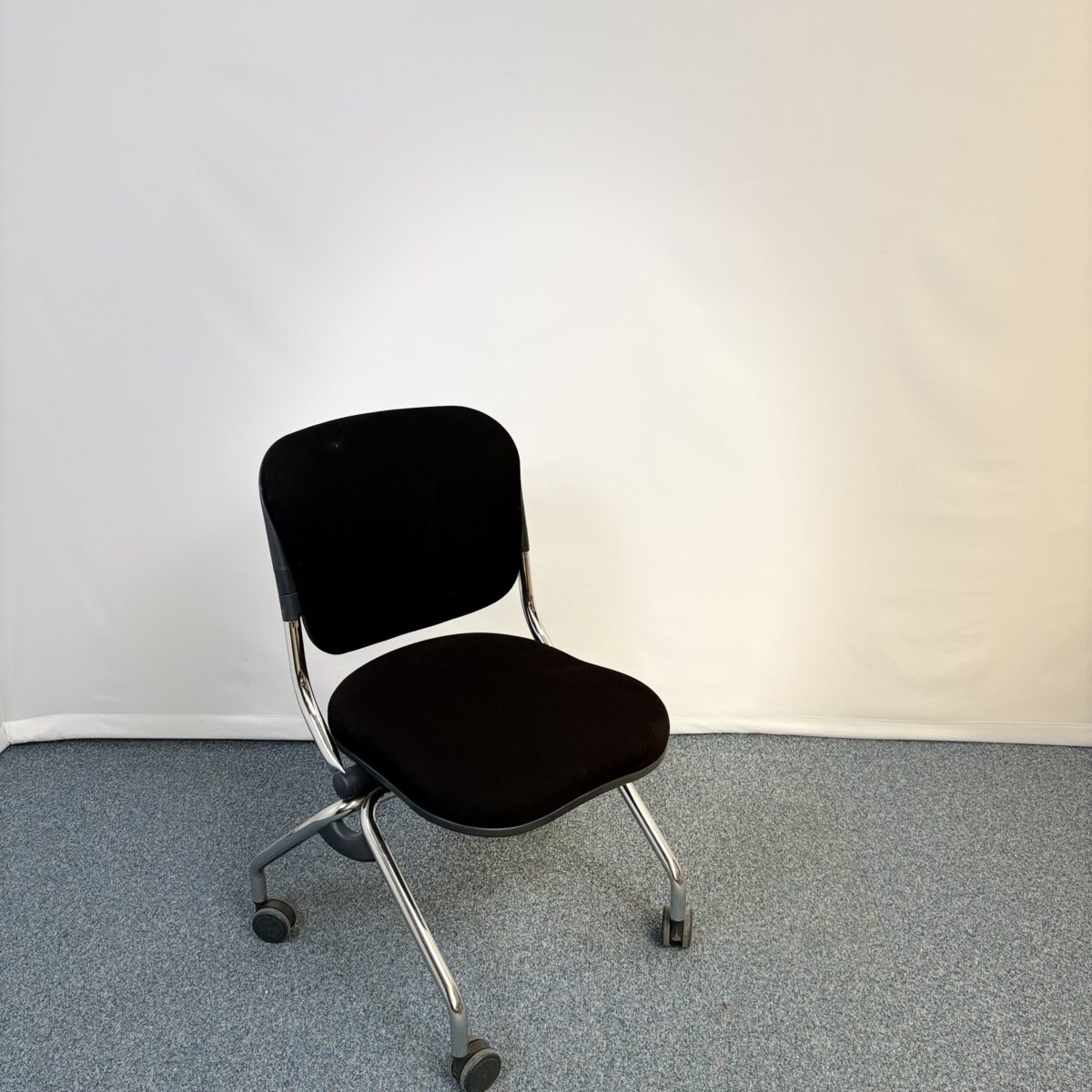 Chaise visiteur en métal et tissu noir pliante avec roulettes