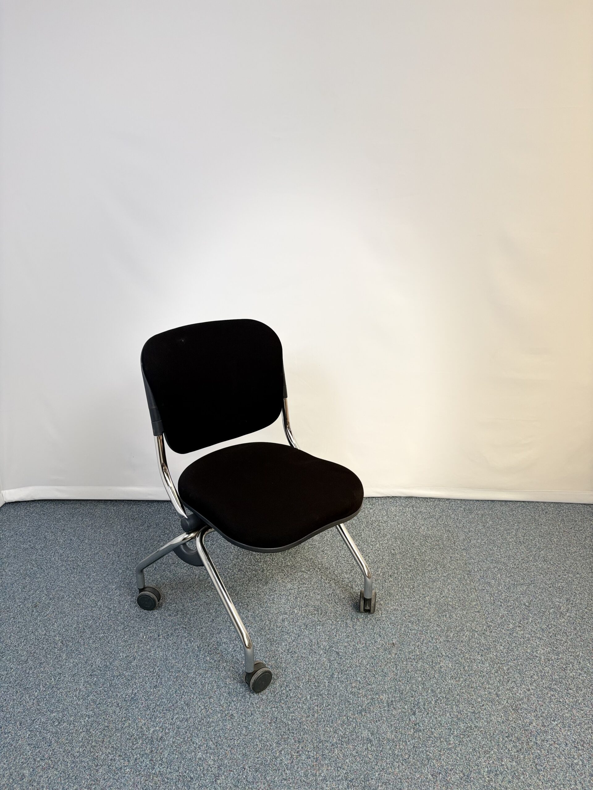 Chaise visiteur en métal et tissu noir pliante avec roulettes