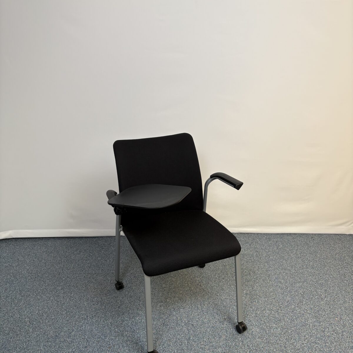 Siège de réunion en plastique et tissu noir avec tablette et roulettes